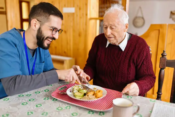 Home caretaker – man helping senior man